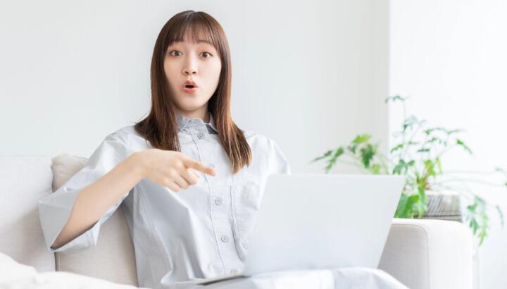 パソコンから音声の警告が出て驚いている女性の様子