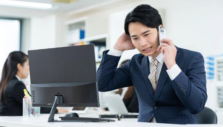 顧客対応の電話を受ける企業担当者