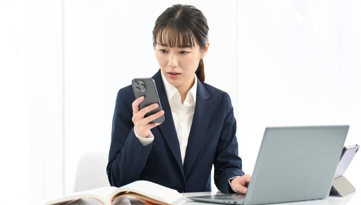スマートフォンを見て固まる女性